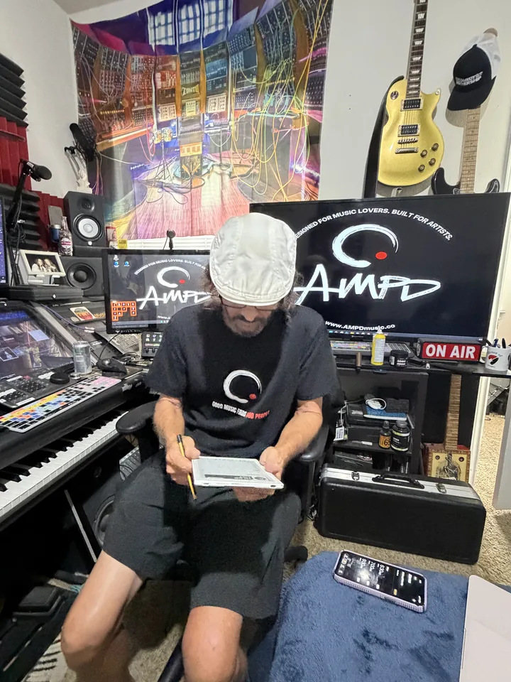 AMPD team member beside music equipment and signage